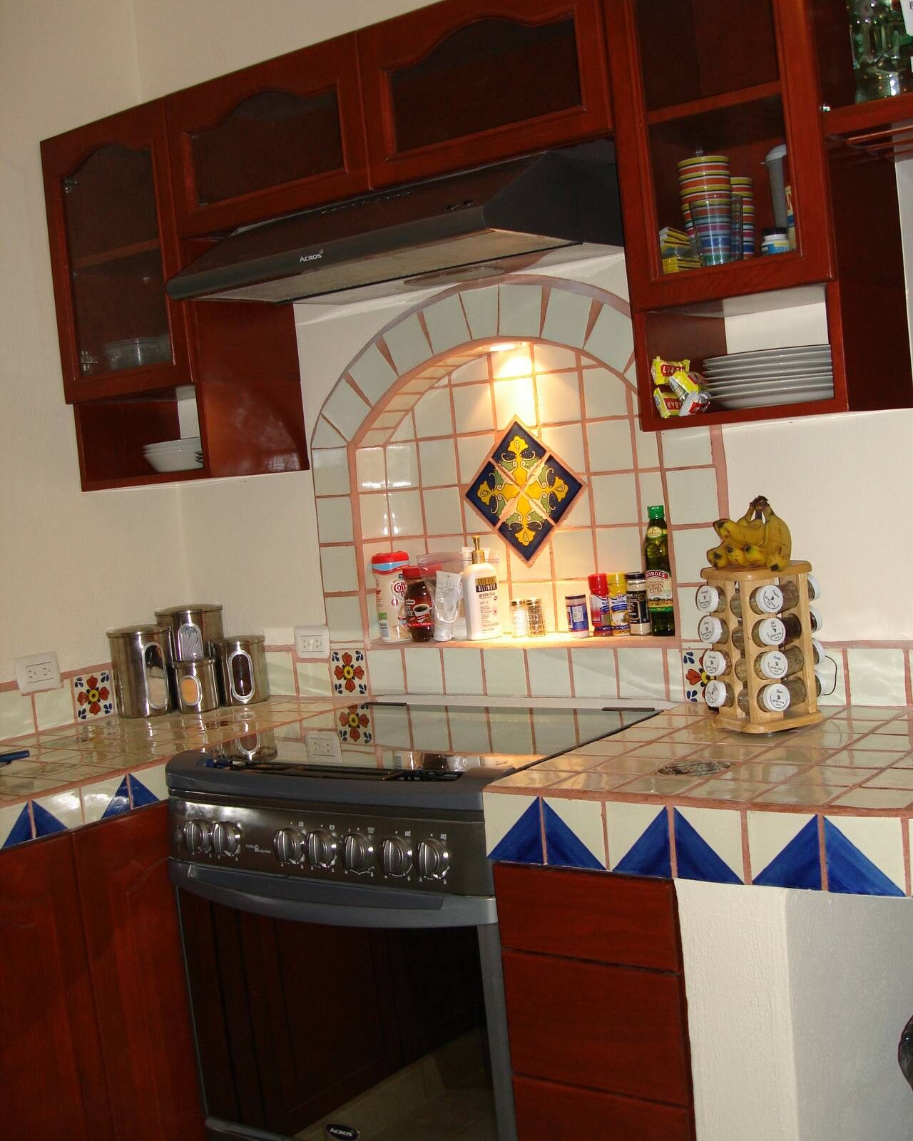 A tiled kitchen with wooden cabinets in a Cozumel home